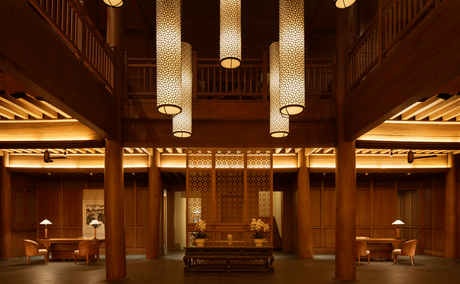 Amandayan lobby with soaring wooden columns and warm lighting illuminating display alcoves.