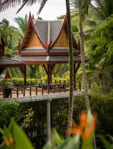 Pavillon ouvert avec voiles orange au Amanpuri resort, entouré de végétation tropicale.