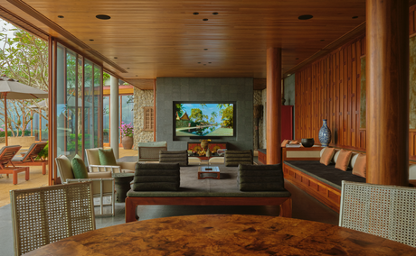 Villa 47 media room with wooden finishes, comfortable seating and views towards the dining area at Amanpuri, Thailand.
