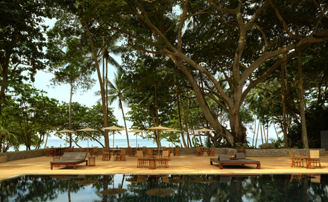 Table set for dining on the pool terrace at Amanpuri resort, overlooking the Andaman Sea.