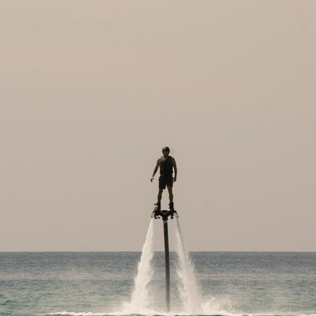 Model performing flyboarding off the coast at Amanpuri resort, Thailand.