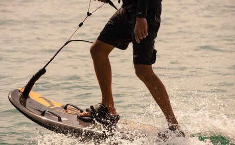 Watersports instructor demonstrating lampuga technique in shallow water at Amanpuri, Thailand.