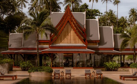 Pavillon principal avec piscine au resort Amanpuri en Thaïlande, architecture traditionnelle thaïe et palmiers.