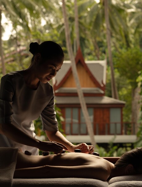 Therapist preparing hot stones for treatment at Amanpuri's spa house in Thailand.