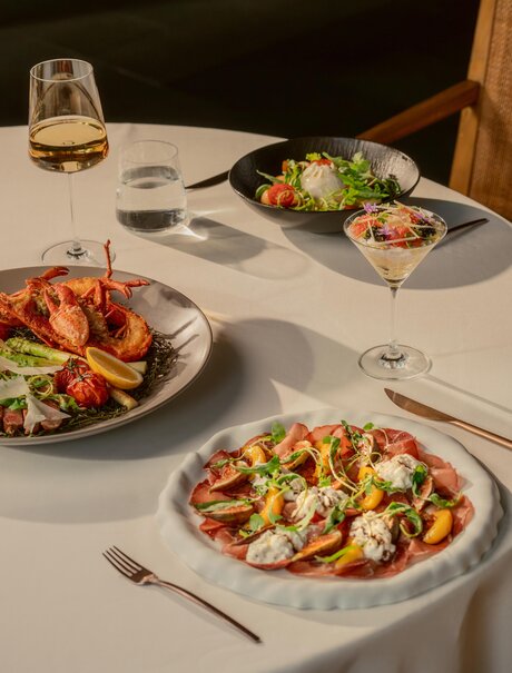 Arva dishes presented on white plates at Amanyangyun's dining venue, featuring vibrant salads and prepared ingredients.