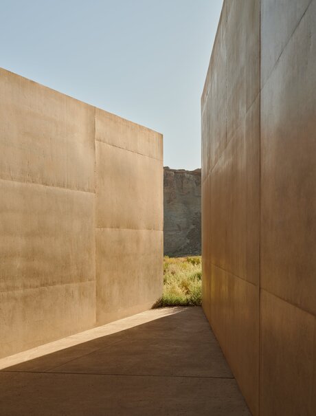Narrow slot window framing desert landscape between copper-clad walls at Amangiri.