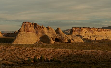 Amangiri's red rock formations rise from the desert landscape at golden hour in Utah, USA.