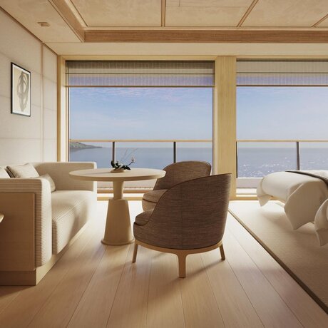 Deluxe suite at Aman at Sea with floor-to-ceiling windows framing seascape views, neutral furnishings, and natural light.