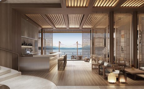 Principal bedroom with ensuite at Aman at Sea, featuring floor-to-ceiling windows overlooking the sea.