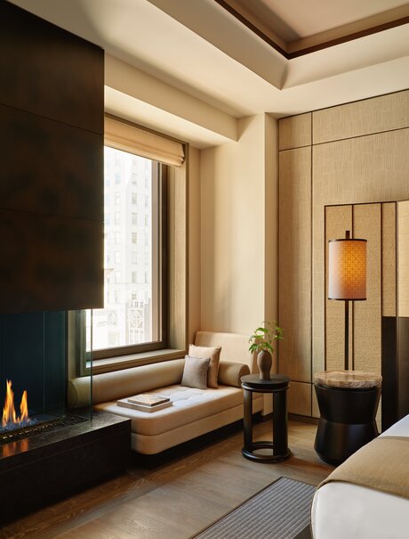 Premier Suite with window seating area at Aman New York, featuring neutral tones and contemporary design.