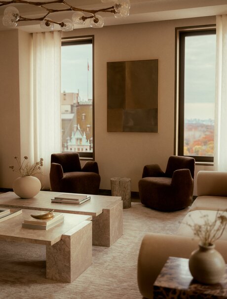 Aman New York three-bedroom penthouse living room with floor-to-ceiling windows, leather seating, and neutral tones.