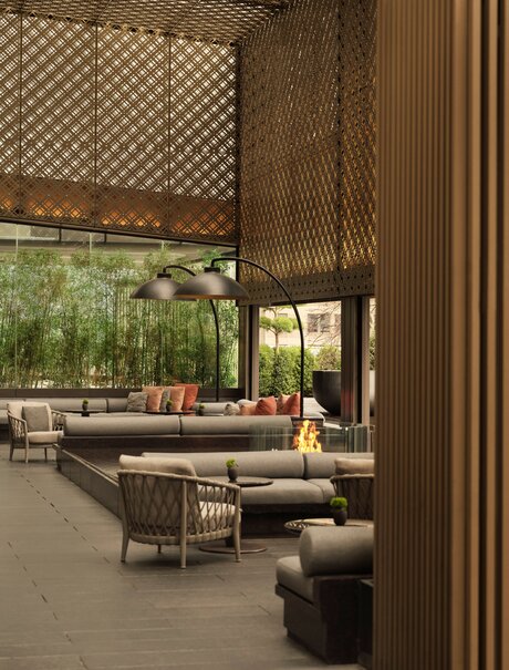 Garden Terrace lounge at Aman New York with woven screens, seating areas, and views to greenery.