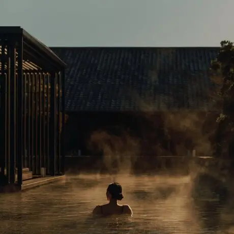 Personne dans un bassin thermal extérieur à la vapeur, Amanemu resort, Japon.