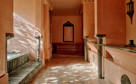 Pool pavilion with terracotta walls and marble flooring at Amanjena, Morocco.