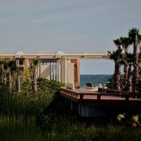 Beachfront casita at Amanvari with ocean views beyond palm trees and coastal vegetation.