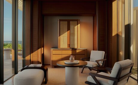Beachfront casita living area at Amanvari with floor-to-ceiling windows, contemporary furnishings, and warm lighting overlooking Mexico's coastline.