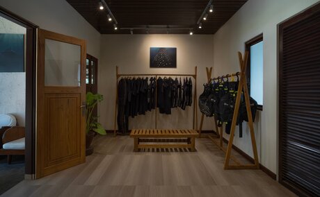 Amanwana dive centre interior with wooden flooring, diving equipment displays, and warm ceiling lighting.