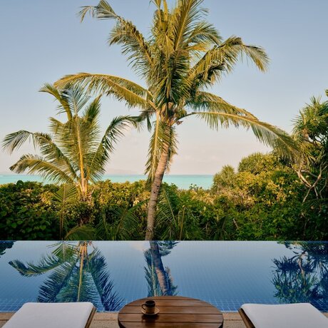Grand Beach Pool Casita with infinity pool overlooking tropical palms at Amanpulo, Philippines.