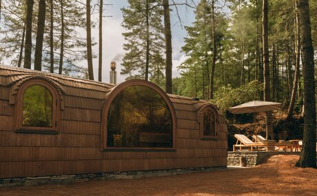 Wooden sauna building nestled amongst tall pine trees at Amankora's Paro Lodge, Bhutan.