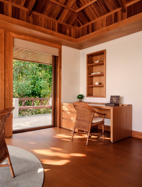 Grand Beach Pool Casita bedroom at Amanpulo with wooden furnishings and garden views.