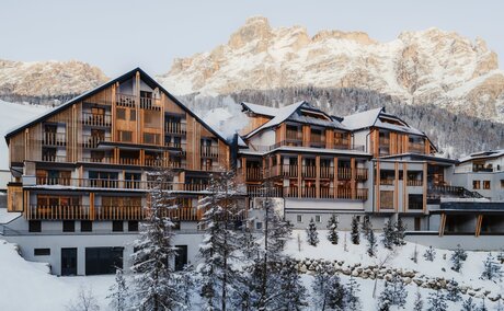 Aman Rosa Alpina exterior with snow-covered Alpine peaks in the background, Italy.