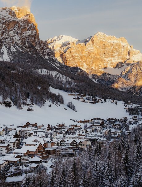 Aman Rosa Alpina nestled beneath snow-capped Alpine peaks at golden hour, Italy.