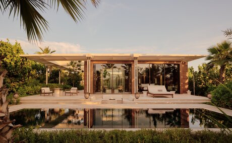Estuary Casita with wooden pergola overlooking still water at Amanvari, Mexico, at sunset.