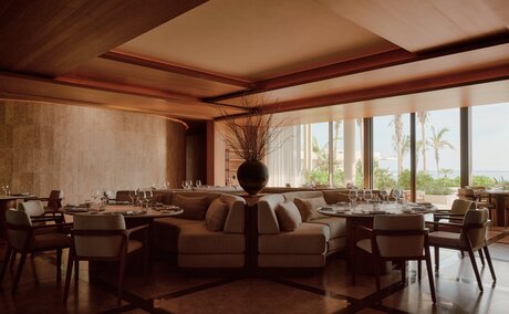 Amanvari's serene lounge with warm wood finishes, comfortable seating, and natural light from expansive windows.