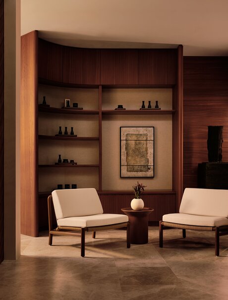Spa entrance at Amanvari with shelved wooden alcove, seating area and warm lighting.
