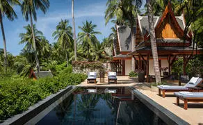 Ocean pool pavilion at Amanpuri with palm trees and loungers overlooking serene waters.