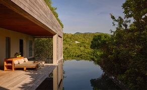 Amanoi resort forest wellness pool villa with terrace overlooking still waters and lush vegetation.