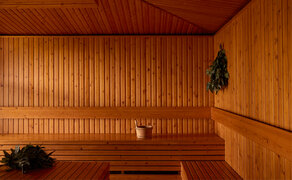 Amanoi resort-ის ხის ფილებით კედლებიანი სველი აბაზანა, რომელიც განათებულია თბილი ღია შუქით.