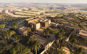 Aerial view of Amansamar villa surrounded by golf course and desert landscape.