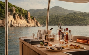 Catamaran deck with dining setup overlooking Ha Long Bay, Amanoi, Vietnam.