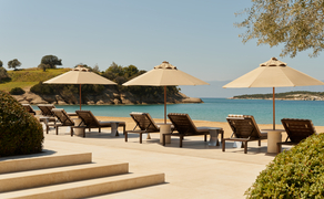 アマンゾイのリゾートビーチクラブ、パラソルとラウンジャーが並ぶ海辺のテラス