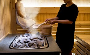 Amanoi-ի կողմից մեկ անձ տաք քարերով դեմքի բուժում կատարում կաղմում անդամ անհանգստանում շոգե պրոցեդուրայի ժամանակ: