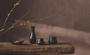 Aman Skincare products displayed on wooden surface with dried botanicals at Amanoi.