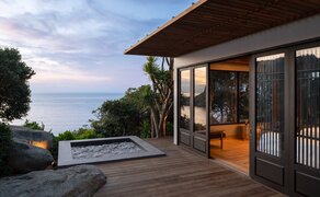 Amanoi Ocean Pool Residence with outdoor jacuzzi overlooking the Vietnamese coastline at dusk.