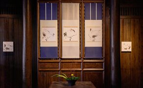 Amanfayun exhibition main hall entrance with wooden doors and blue panels displaying artwork.