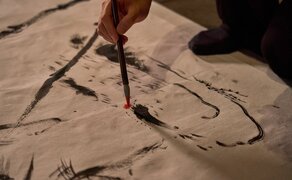 Artist creating calligraphy on-site at Amanfayun during exhibition.