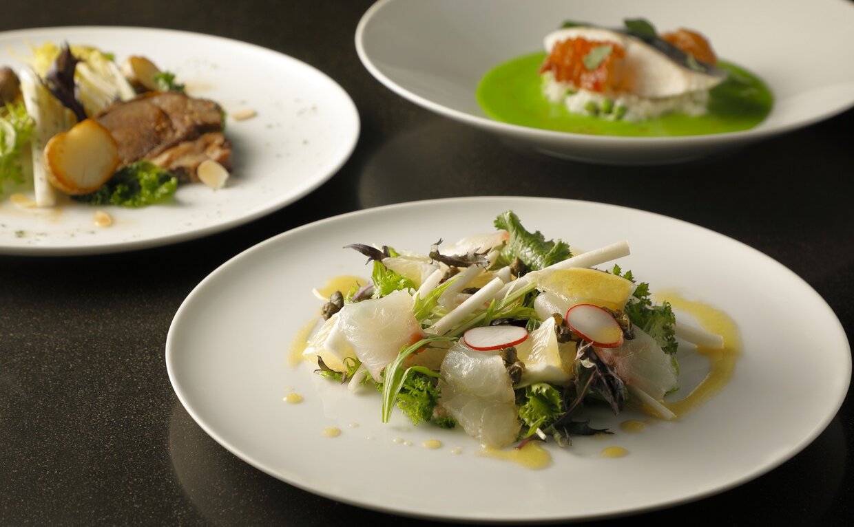 アマン東京のカフェで提供される春の野菜とハーブを使った料理。白いプレートに盛り付けられた3皿。