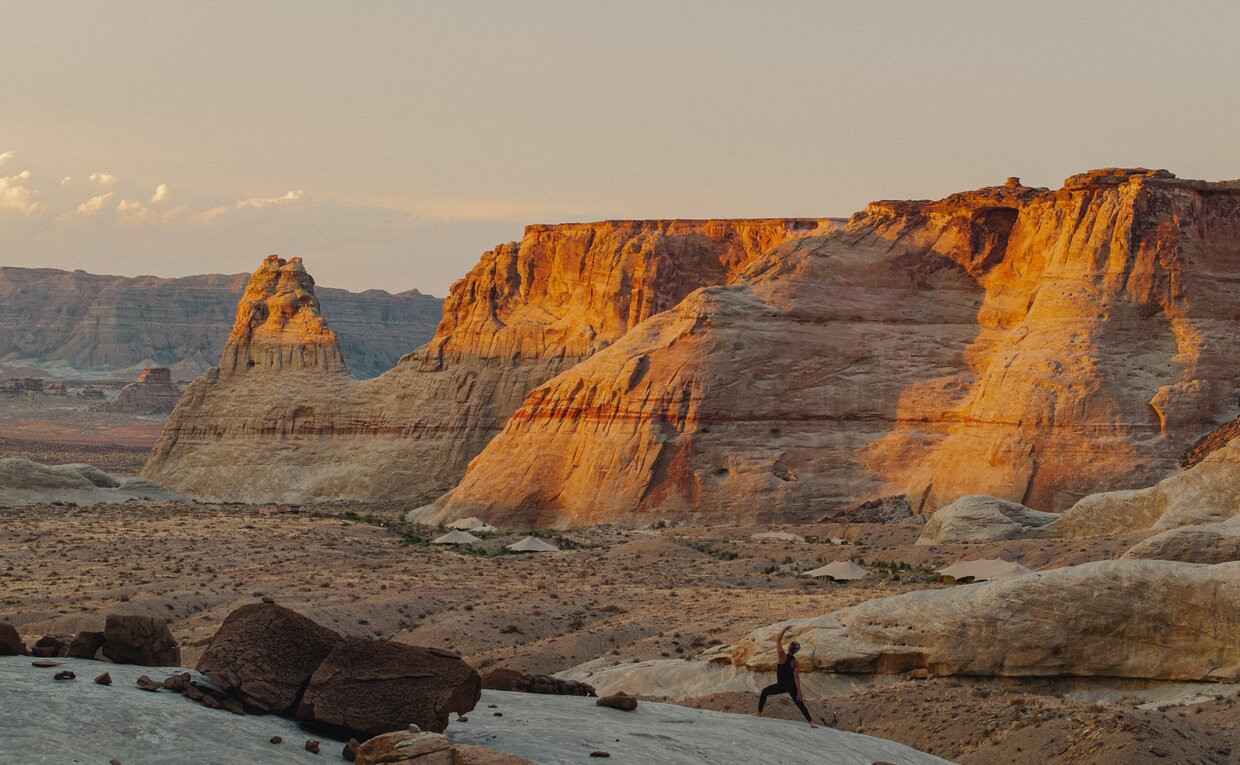 Yoga session on red rock formations at Amangiri resort, Utah, at sunset.