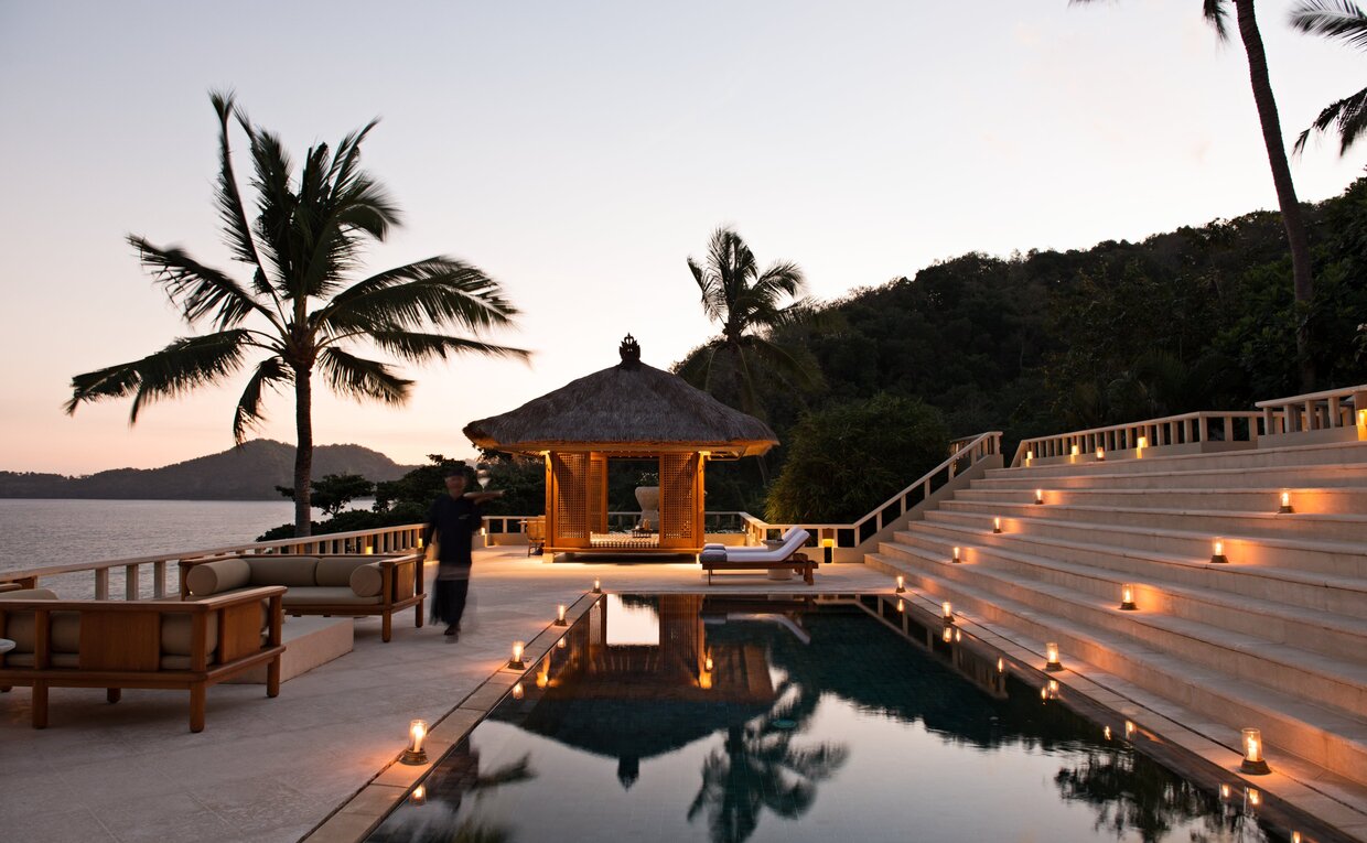 Amankila Suite with infinity pool overlooking the Bali coastline at dusk.