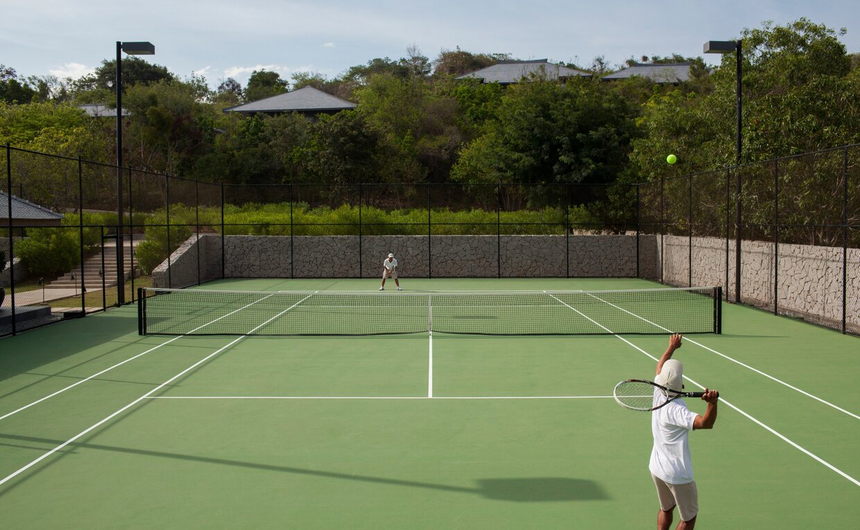 Tennis court at Amanoi resort in Vietnam with player holding racket.