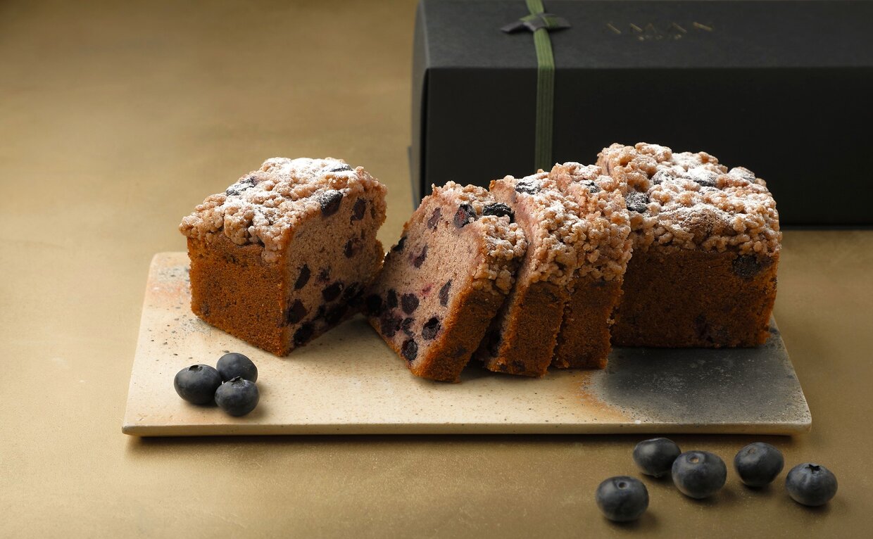 Sliced blueberry pound cake dusted with icing sugar at Aman Kyoto, garnished with fresh blueberries.