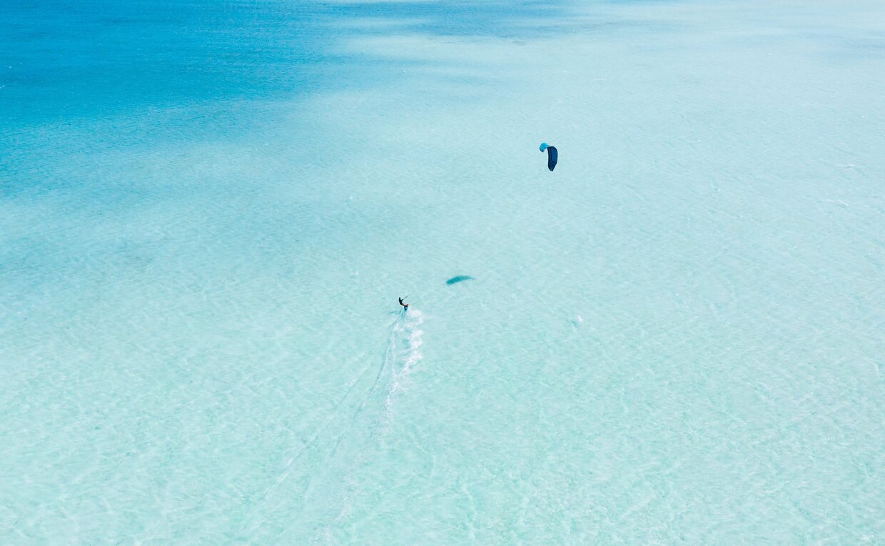 Kitesurfeur dans le lagon turquoise d'Amanpulo, une station balnéaire aux Philippines.