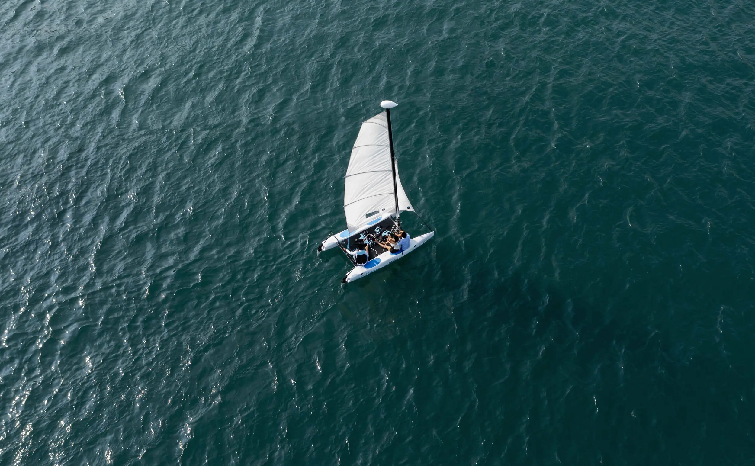 Aerial view of a white sailing yacht on turquoise waters at Amanoi.