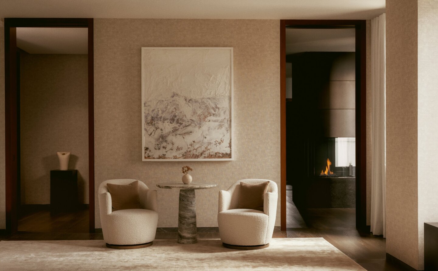Three-bedroom penthouse at Aman New York with neutral seating area, framed artwork, and dark doorways.