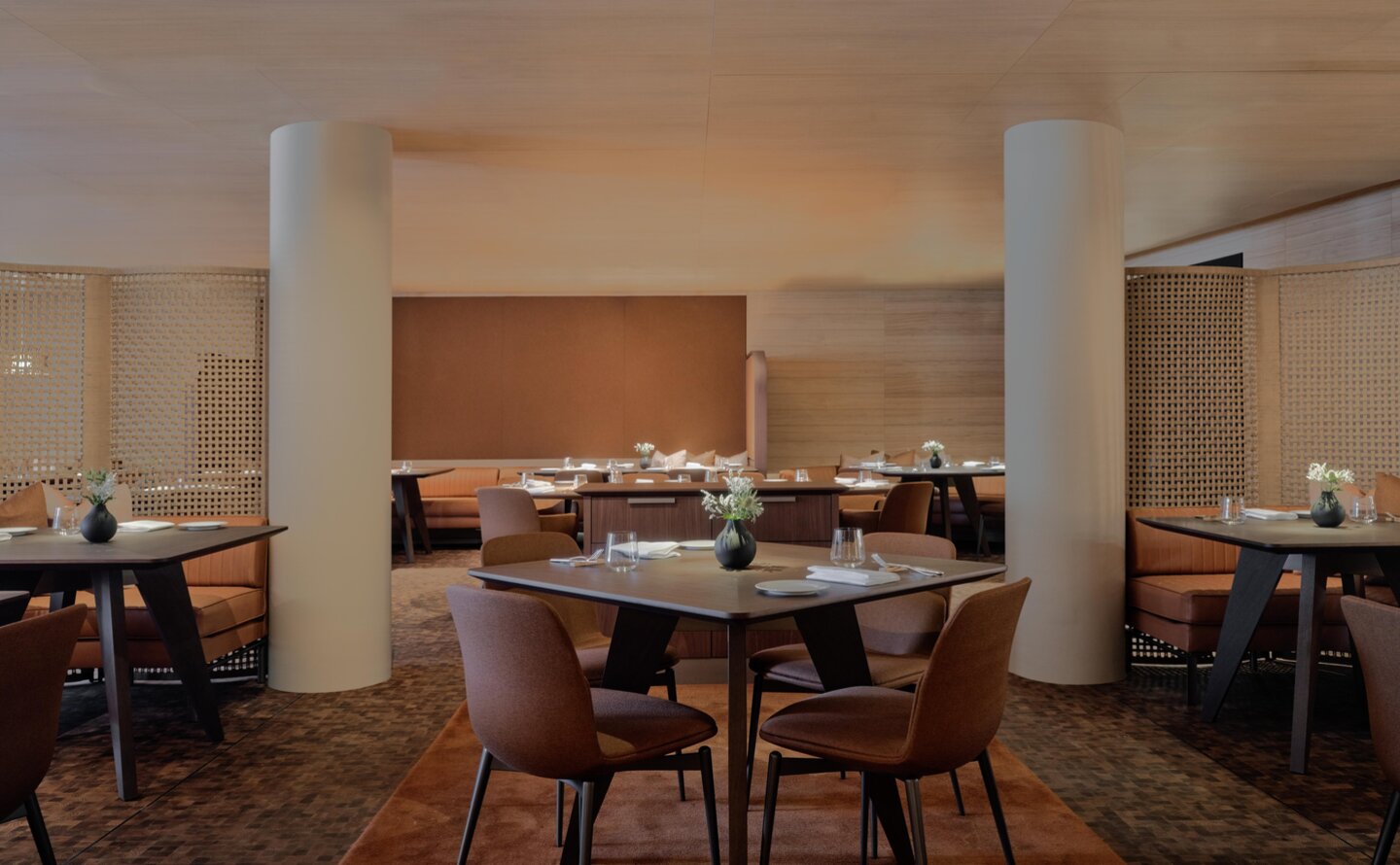 The Grill dining venue at Aman Rosa Alpina resort, featuring warm wood tones and intimate table settings.