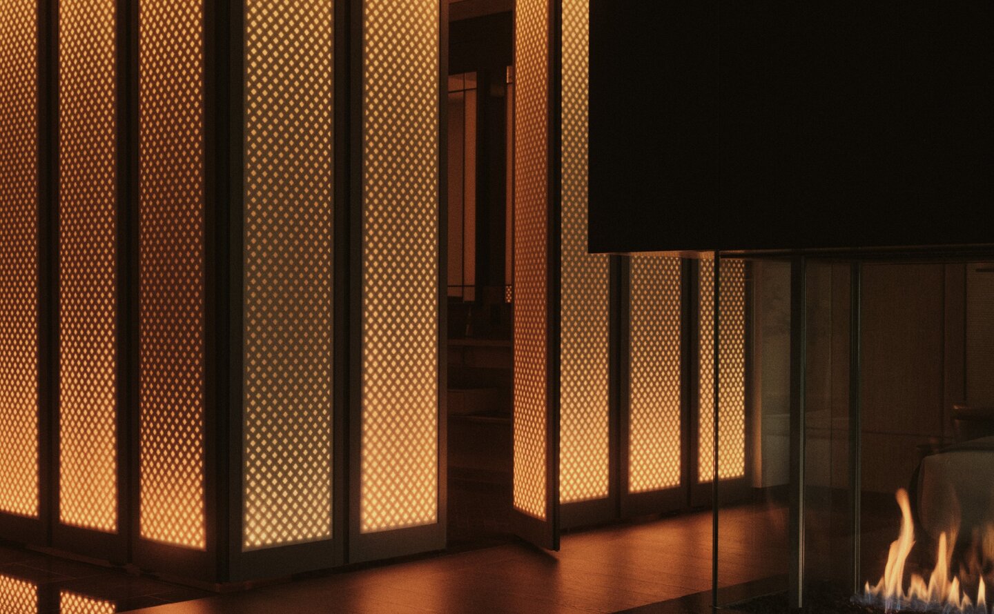 Grand Suite bedroom with illuminated wooden partition screen and fireplace at Aman New York.